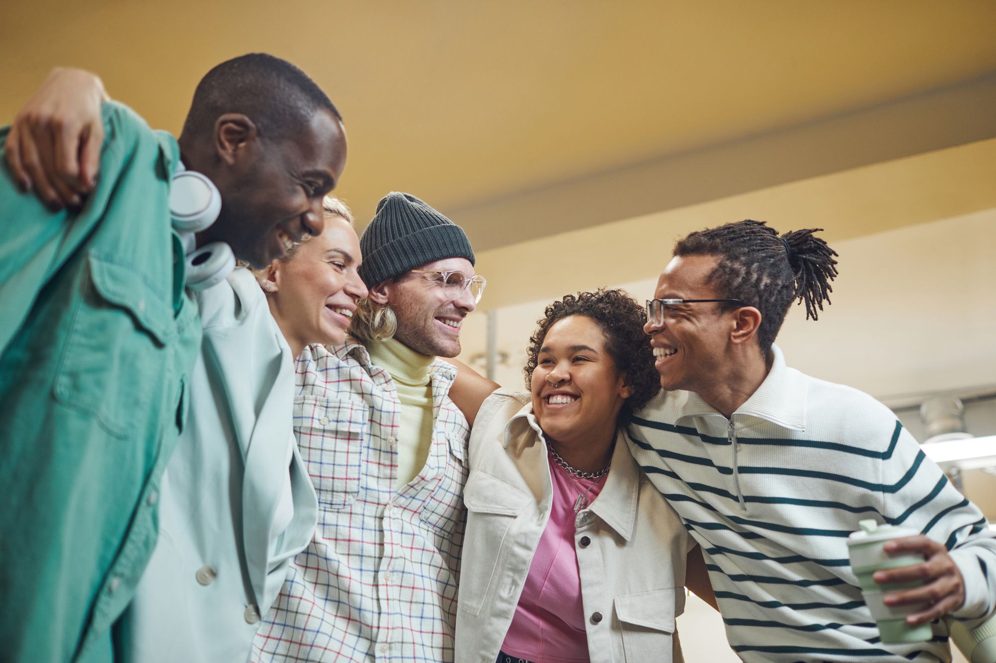 Colleagues smiling together with their arms around one another